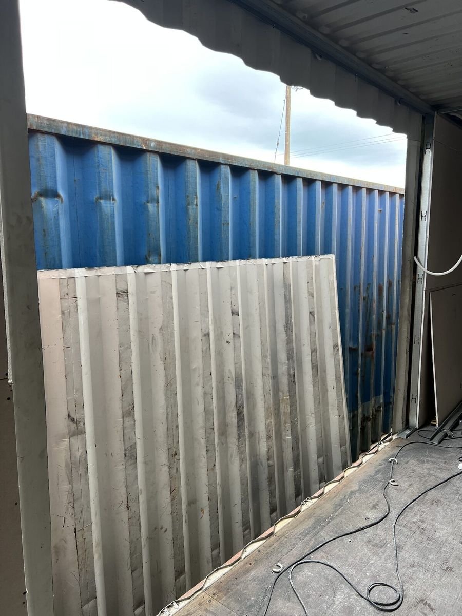 El contenedor en el taller, con un panel de placa listo para colocar.