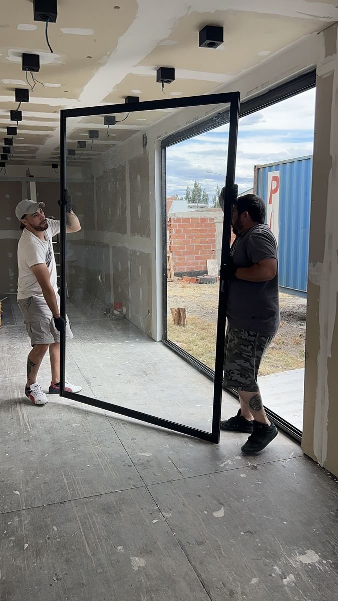 Equipo de Patagonia Containers instalando una gran abertura vidriada en un módulo container, Sarmiento